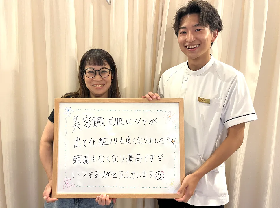 笑顔の患者と並ぶ整体師