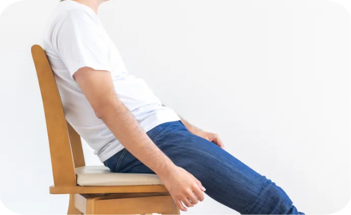 椅子に斜めの姿勢で座る男性